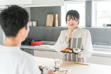 Obraz premium お弁当を出しながら謝る妻・主婦と夫・旦那（新婚・結婚生活） 