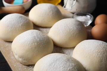 Raw dough balls with flour, eggs and salt on table