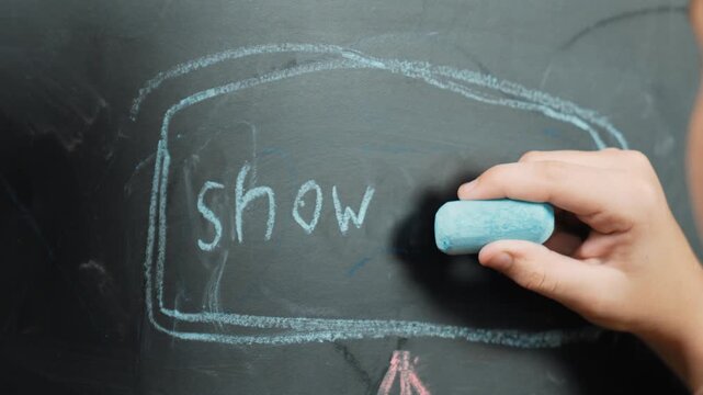 Closeup of smart student or boy writing prompt on blackboard. Child plan project and setting engineering system and brainstorm creative idea wrote on blackboard. Focus on hand. Site view. Erudition.