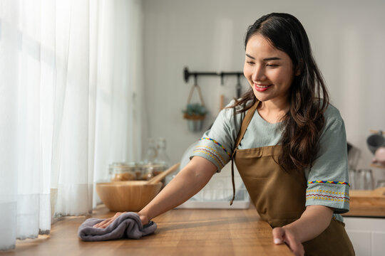 Asian beautiful cleaning service woman worker cleaning kitchen at home. 