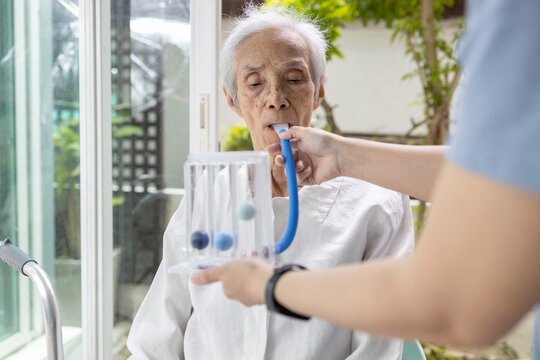 Female caregiver holding spirometer,caring and support for senior woman at nursing home,old elderly with spirometer,exercise the lung,help the lung expansion,concept of service,medical,health care