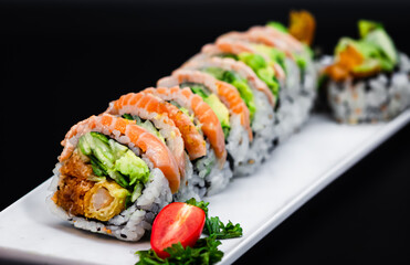 Avocado, cucumber, shrimp tempura, and spicy salmon roll topped with torched salmon