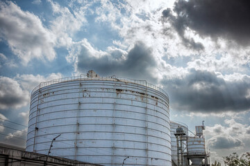 Large Industrial Storage Tanks with Power Plant in Background