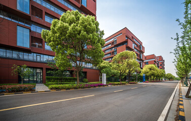 Obraz premium Modern Red Buildings with Trees and Empty Street