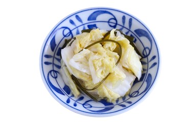 A close up shot of Japanese style pickled Chinese cabbage on a porcelain plate on white background.
