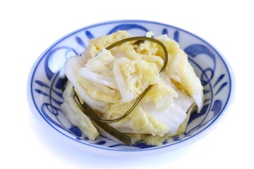 A close up shot of Japanese style pickled Chinese cabbage on a porcelain plate on white background.