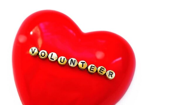 Word  Volunteer on red heart, White background.