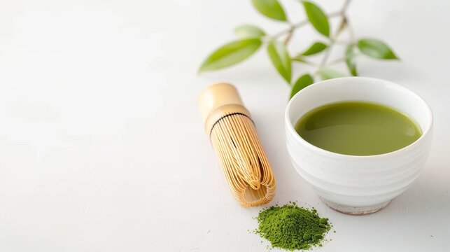 Steaming matcha tea in a simple cup, paired with a bamboo whisk, isolated on a white background with generous copy text space