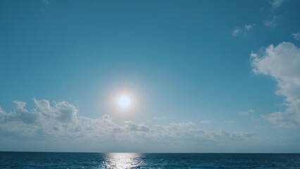 Fototapeta premium the sun is shining over the ocean under some clouds,