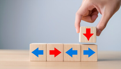 Hand putting a wooden cube with red arrow showing the opposite to blue arrows direction on