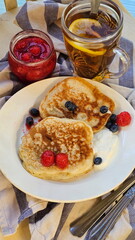 Berry pancakes and fried eggs with lemon tea