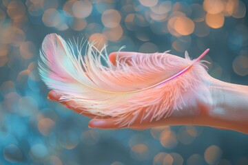 Hand holding pink and blue feather