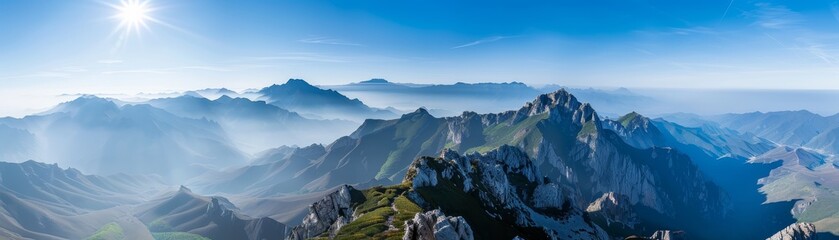 A mountain range with a blue sky and a sun in the background