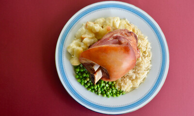 German style pork knuckle with sauerkraut cauliflower bake and green peas.