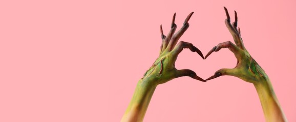Hands of witch making heart on pink background with space for text. Halloween celebration