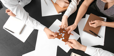 Team of business people doing puzzle in office