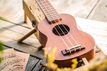 A wooden ukulele placed on a wooden surface