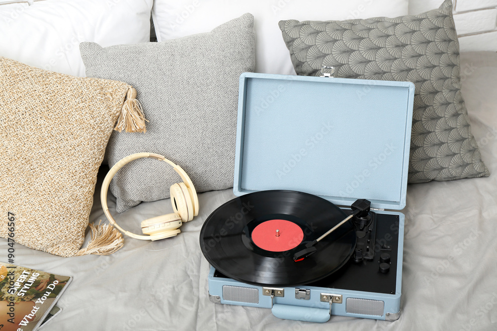 Wall mural record player with vinyl disk and headphones on bed in room