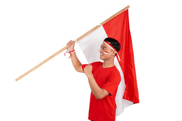 Indonesian man celebrating Indonesia's independence day on 17 August by holding the Indonesian flag...