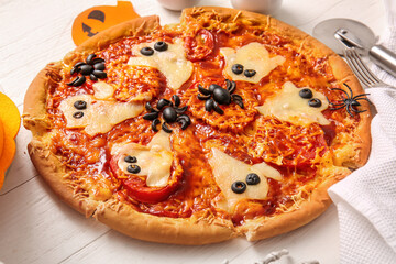 Tasty pizza for Halloween celebration on white wooden background