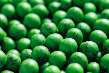Closeup green dragee, chocolate covered nuts, sweet candy background