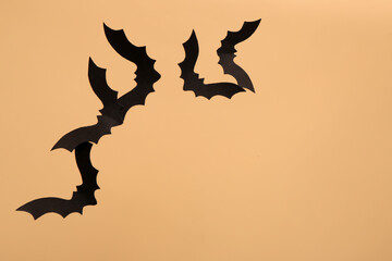 Paper bats for Halloween party on beige background