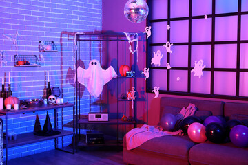Interior of dark living room with Halloween decor and shelf units