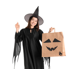 Young woman dressed for Halloween as witch with gift bag on white background