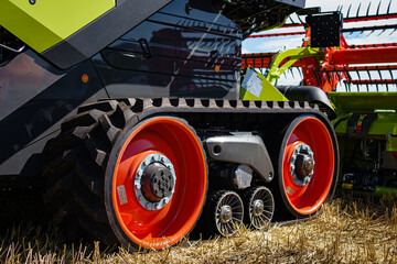 Harvesting wheat with a green combine. Farm machinery harvesting wheat crop. Green harvester in...