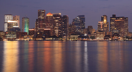 Obraz premium Boston skyline and harbor illuminated at night reflected on the Atlantic Ocean, USA 
