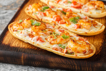 Shrimp Scampi Garlic Bread sandwiches with mozzarella, tomatoes and parsley closeup on the wooden board on the table. Horizontal