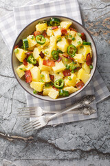 Potatoes jalapeno salad with bacon, green onions in mexican style close-up in bowl on table. Vertical top view from above