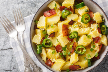 Spicy Potato Jalapeno Salad with Bacon, Green Onions and Mayo Close-up in Bowl on Table. Horizontal top view from above