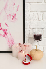 Halloween pumpkin with ring, drink and candles on dressing table in room, closeup