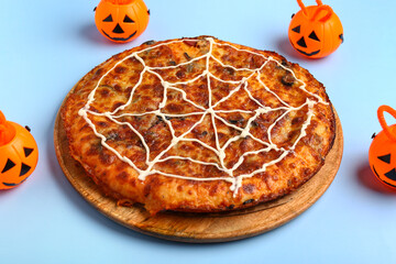 Wooden board with tasty pizza and pumpkins for Halloween party on blue background