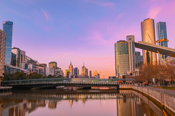 Fototapeta premium Melbourne's City Skyline behind the Yarra River during a pink Sunset in Australia during winter. 