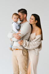 Mother and father hold a one-year-old son of a child in their arms. Happy family with a baby