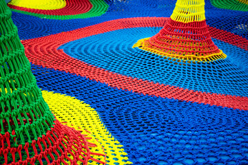 Close up colorful rope net labyrinth for children at playground, Details of texture colorful braided ropes in various shapes in the indoor playground.