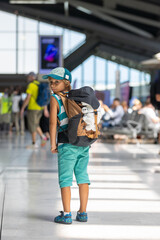 Sweet children, brothers, boys, waking hand in hand at the airport, carrying suitcases and backpacks