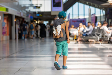 Sweet children, brothers, boys, waking hand in hand at the airport, carrying suitcases and backpacks