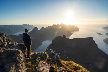 Fototapeta premium A man wachting the midnightsun on summit Grytetippen on Senja, Norway.