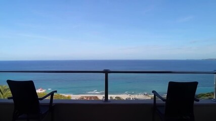 A serene ocean view from a balcony featuring two chairs, evoking feelings of relaxation and travel