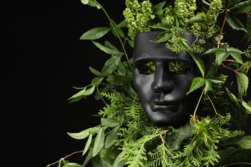 Theatrical performance. Plastic mask and floral decor on black background, space for text