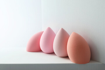 Stylish presentation of makeup sponges on light grey background