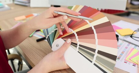 Designer holds and points to color palette