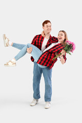 Happy young couple with chrysanthemum flowers on white background