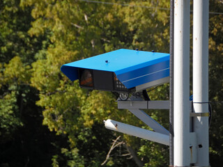 Close-up Of Security Camera On The Street. Control and monitoring system. Metal Pole. Green trees. july 2024. Ust-Kamenogorsk (kazakhstan)