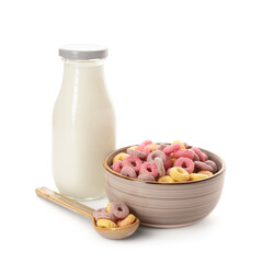 Bowl with colorful sweet cereal rings and bottle of milk on white background