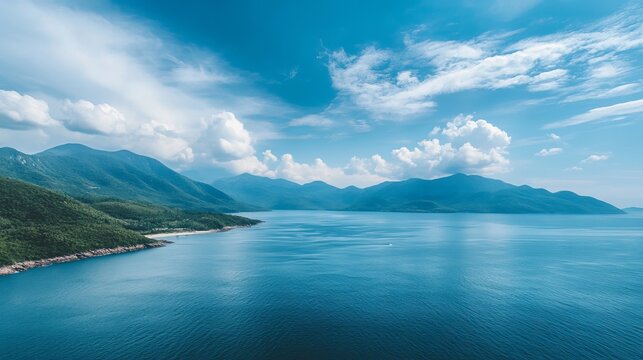 A high-angle view of the sea and mountains against a blue sky.