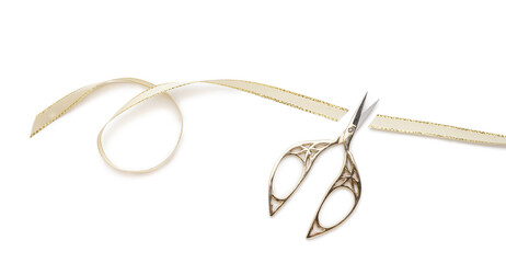 Scissors with cut ribbon on white background
